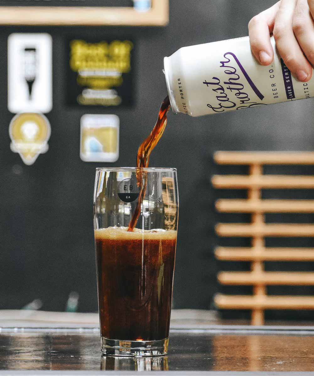A promotional photo for East Brother Beer co. Baltic Porter being poured into a tall glass