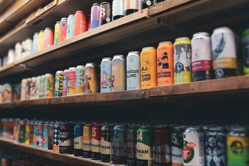 Multi colored craft beer cans on a store shelf