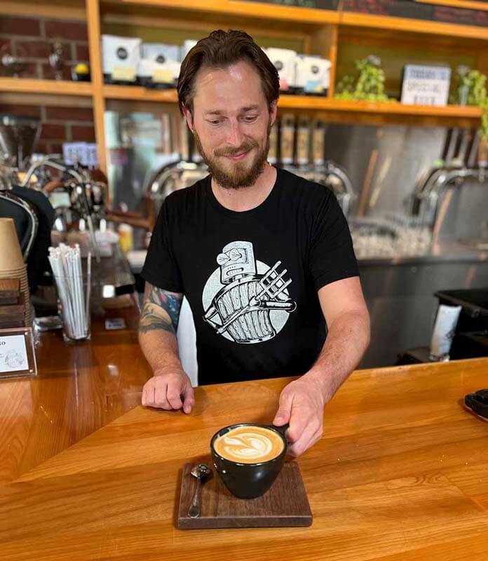 A bartender at Wooden Robot Brewery serving a mug of coffee beer