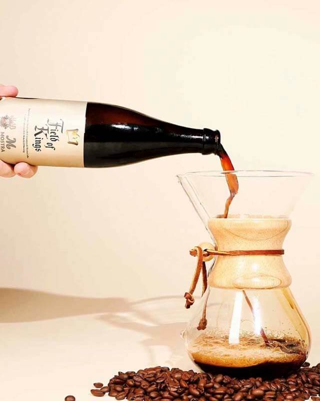 A bottle of Field of Kings coffee beer being poured into a pour over coffee maker