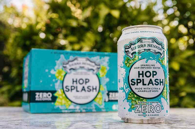 A promotional photo for Sierra Nevada's Hop Water non-alcoholic hop water beverage featuring a can and a 12-pack in an outdoor setting