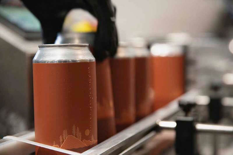 Craft beer cans going through the canning process at Fair Isle Brewing