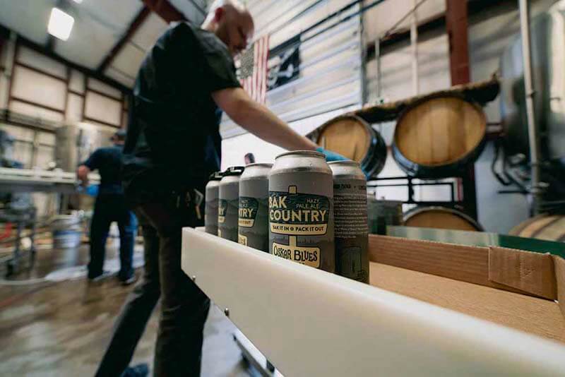 Cans of Oak Country craft beer from Oskar Blues Brewery going through the canning process