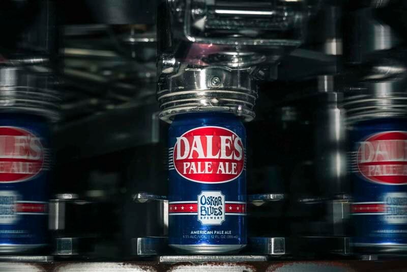 A close up photo of Dale's Pale Ale from Oskar Blues Brewery going through a canning machine