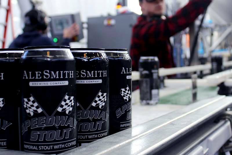 Craft beer cans of Speedway Stout from AleSmith Brewing Company going through the canning process