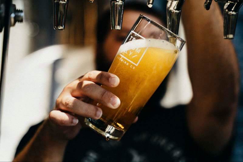 A trademarked craft beer being poured from tap at a bar or brewery
