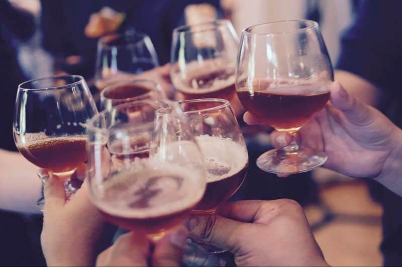 Upclose photo of people toasting a trademarked craft beer