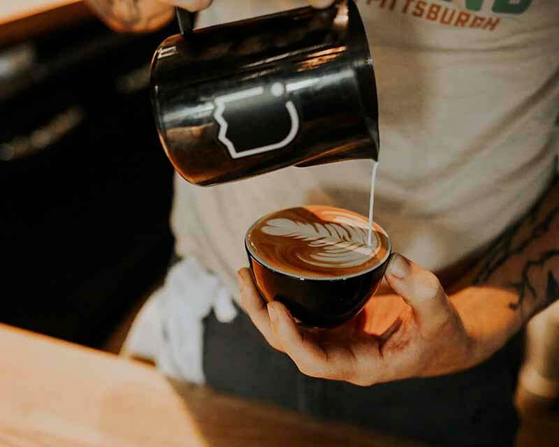 Aerial shot of a bartender making latte art in a mug at Trace Brewing in Pittsburgh