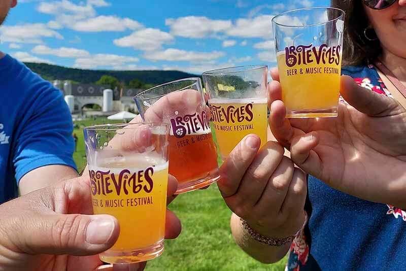 Various people toasting BriteVibes glasses from the New York State Brewers Association event