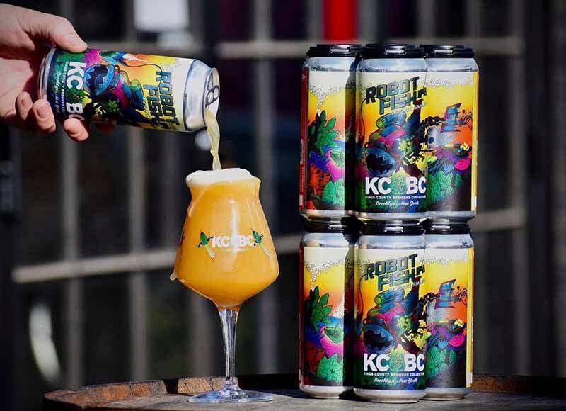 A promotional photo of a stack of Robot Fish craft beer cans with one being poured into a KCBC glass