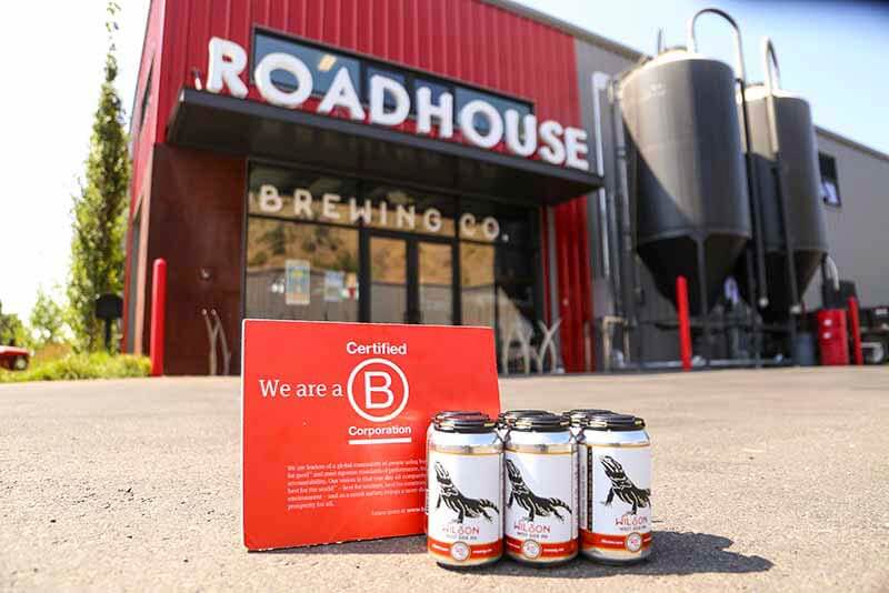 Roadhouse Brewing Co. photo of exterior and a six pack with a sign promoting that they are a B Corp Certified Brewery