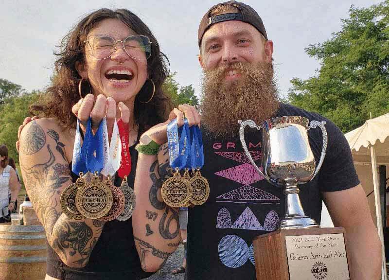 Two craft brewers holding award medals from the New York State Craft Brewers Association