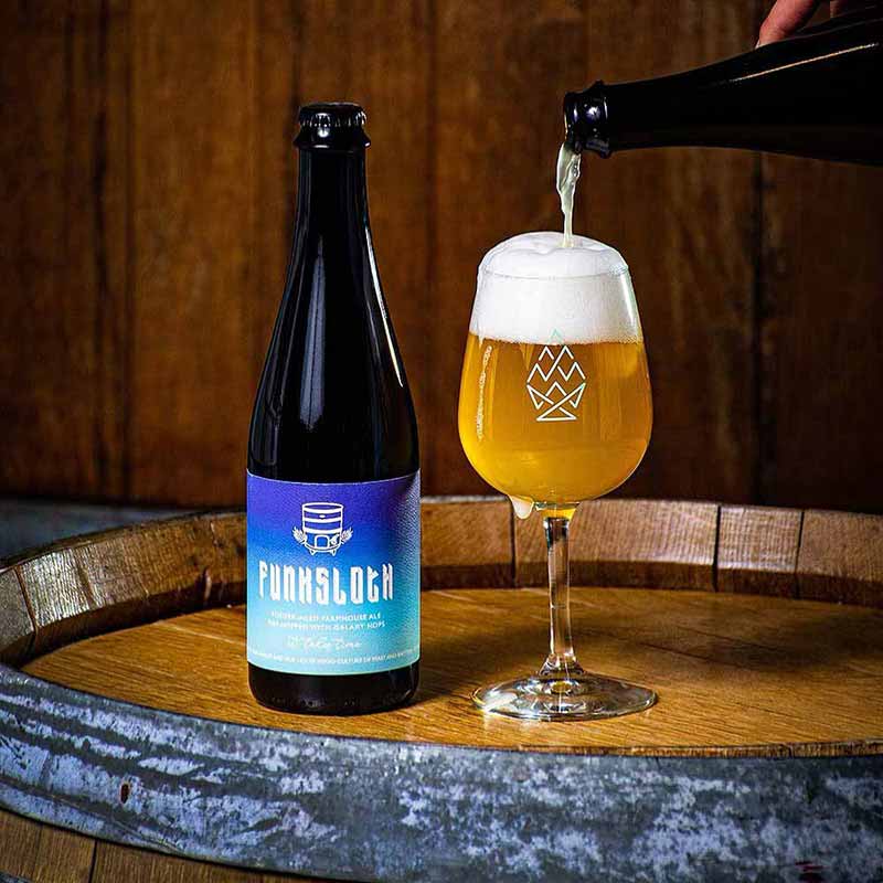 A promotional photo of Bow and Arrow Brewing Co. Funksloth farmhouse ale