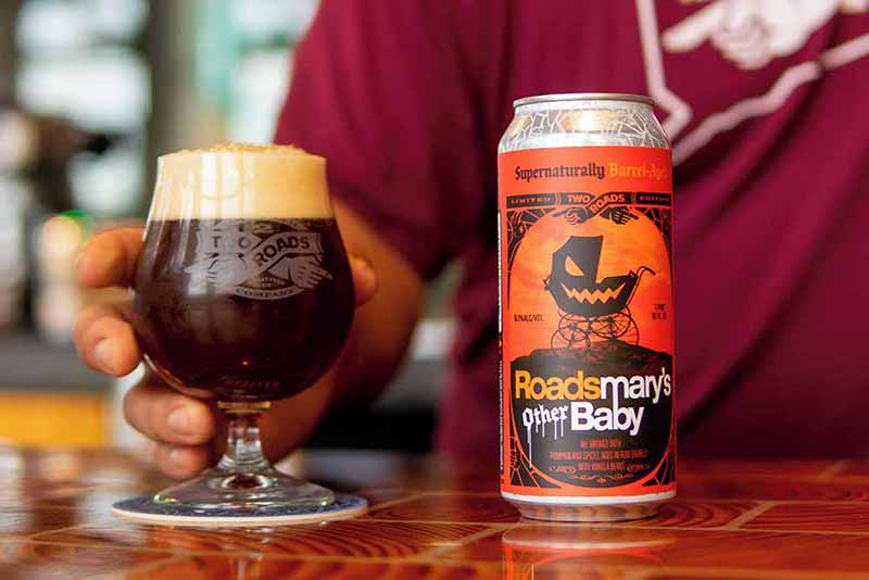 A promotional photo for Rosemary's Other Baby, a pumpkin flavored craft beer from Two Roads Brewing