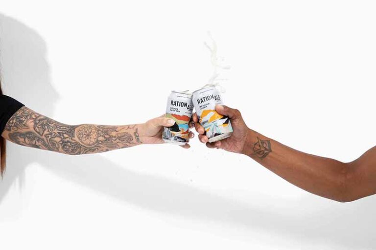Promotinoal photo of two people toasting cans of RationAle craft beer