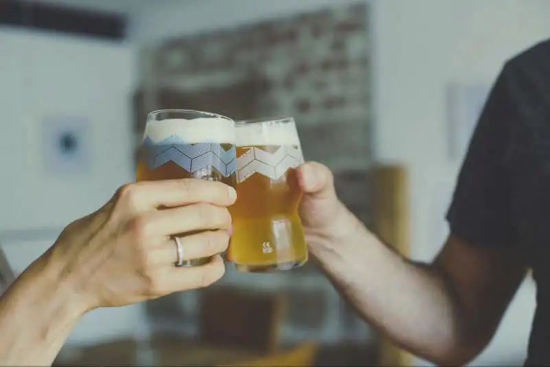 Two people toasting glasses of craft beer