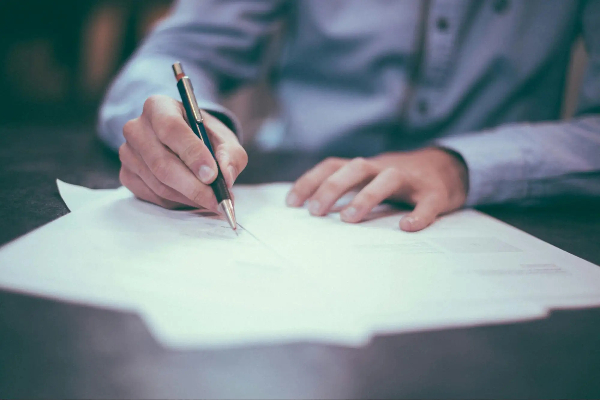 An up close photo of a lawyer signing legal documents