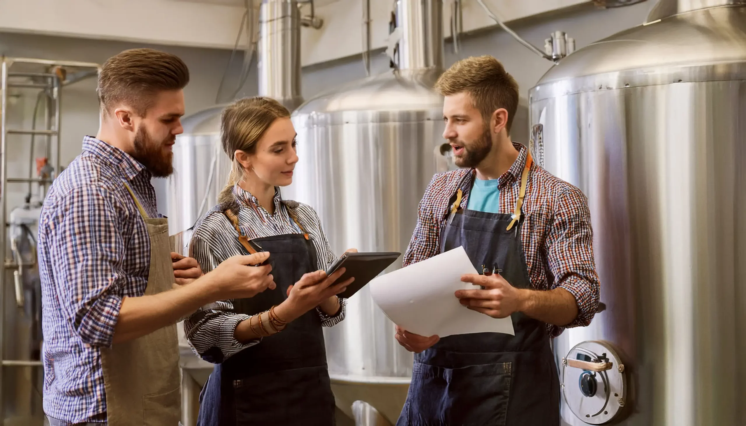 A group of brewers having a meeting on the production floor