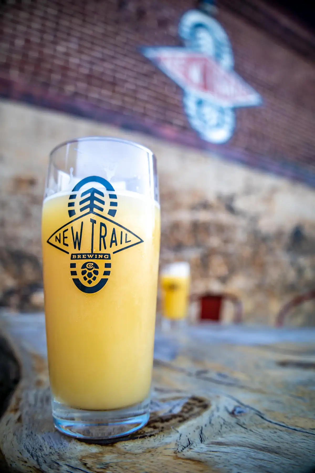 A glass of beer in a New Trail Brewing glass